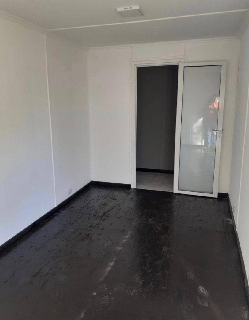 Maison blanche aménagée dans un conteneur de 6 mètres avec baie vitrée